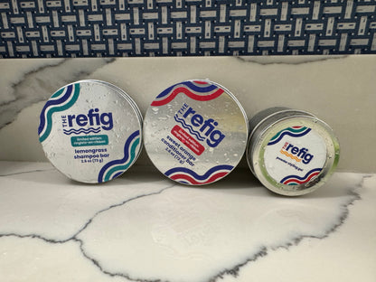 Full-size Wash-and-Go Hair Care Set. Tins of solid bar shampoo, conditioner and powder-to-gel are positioned near sink. Tins are wet to demonstrate the hydrating nature of product.